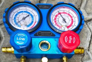 Air conditioner refrigerant gauge used to check Freon levels in a home AC unit, highlighting signs of low refrigerant, AC recharging process, and HVAC maintenance by Family Heating and Cooling. Call us today for help with add refrigerant to home AC, how to recharge home AC, AC refrigerant refill near me, HVAC refrigerant recharge, Freon refill for home air conditioner, AC not cooling needs refrigerant, R-410A refill service, home AC Freon recharge near me, low refrigerant in air conditioner, HVAC technician refrigerant service, AC repair and recharge near me, Freon leak repair, AC cooling repair services, air conditioning recharge service near me, emergency AC repair near me, Family Heating and Cooling AC services, air conditioner recharging service, home AC coolant top-off, Freon replacement for central AC, refrigerant recharge cost near me.