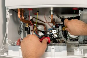 HVAC technician repairing a furnace showing signs of wear, illustrating what fails first on a furnace such as the igniter or blower motor, professional furnace repair and maintenance by Family Heating and Cooling, expert heating service and furnace diagnostics near New Bedford, Fall River, and Taunton. Reach out to us today for help with what fails first on a furnace, common furnace problems, furnace parts that fail first, furnace repair, furnace maintenance, furnace troubleshooting, furnace replacement, heating system repair, HVAC repair, furnace inspection, blower motor failure, furnace igniter issues, pilot light problems, furnace not heating, furnace repair near me, HVAC service near me, furnace maintenance near me, furnace repair services, professional furnace repair, emergency furnace repair.
