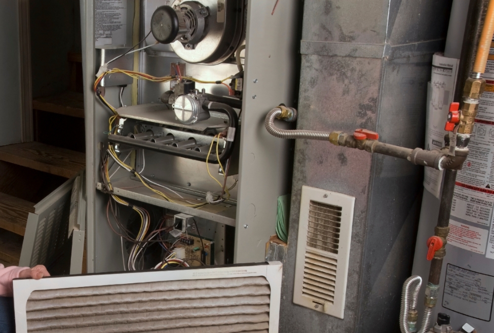 A residential furnace in a home, illustrating common heating system problems, furnace repair costs, and maintenance services, with guidance on whether furnace repair is covered by homeowners insurance provided by Family Heating and Cooling. Reach out today for help with is furnace repair covered by homeowners insurance, furnace repair insurance coverage, homeowners insurance furnace repair, does insurance cover furnace repair, furnace maintenance coverage, furnace replacement insurance, heating system repair insurance, emergency furnace repair, furnace inspection and service, furnace troubleshooting, furnace repair near me, HVAC repair near me, furnace maintenance near me, licensed furnace repair, professional furnace service, affordable furnace repair, residential HVAC services, energy-efficient furnace repair, furnace replacement cost, common furnace problems, Family Heating and Cooling furnace services, furnace repair and maintenance, heating system repair near me, emergency HVAC services near me, reliable furnace repair company.