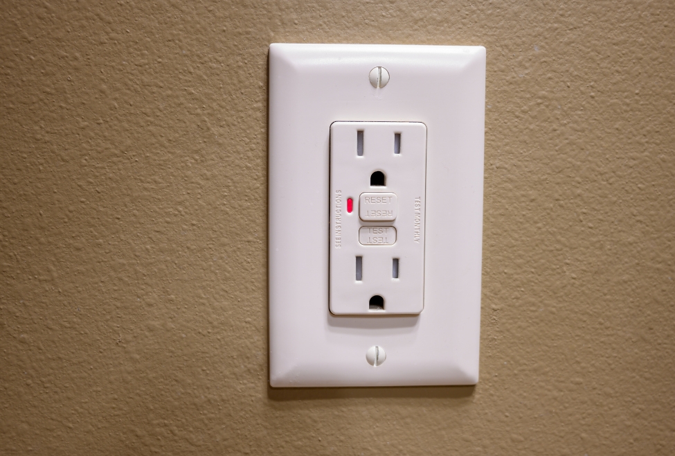 A close-up of a GFCI outlet showing tripped and reset buttons, illustrating signs of a bad GFCI outlet, frequent tripping, electrical outlet issues, and the need for GFCI outlet repair or replacement by licensed electricians from Family Heating, Cooling, Electric and Plumbing. Call us today for help with what are signs of a bad GFCI outlet, GFCI outlet not working, GFCI keeps tripping, faulty GFCI outlet, GFCI outlet repair, replace GFCI outlet, GFCI outlet testing, electrical outlet troubleshooting, bad bathroom outlet, kitchen GFCI problems, outdoor GFCI issues, GFCI outlet installation, GFCI outlet wiring problems, GFCI breaker not resetting, GFCI safety inspection, GFCI outlet near me, electrical repair near me, licensed electrician near me, GFCI outlet replacement near me, tripping GFCI outlet repair, professional electrical services, home electrical troubleshooting, outlet repair and replacement, GFCI circuit problems, GFCI code compliance, kitchen outlet repair, bathroom outlet repair, outdoor outlet repair.
