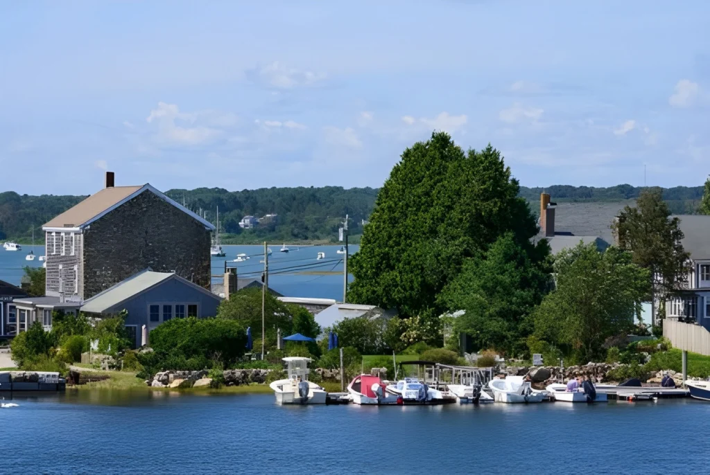 Scenic view of Westport Point, MA with boats and greenery near the water.