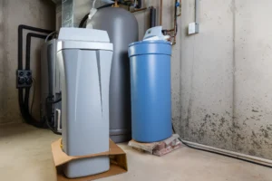 Modern water filtration system and storage tank in a basement setting.