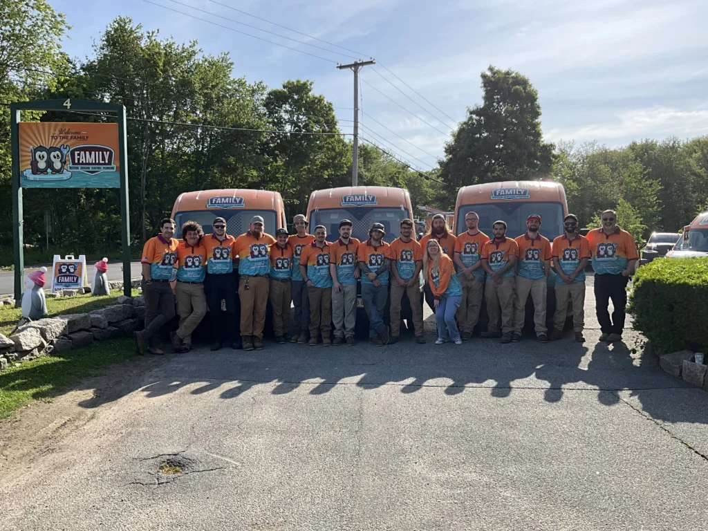 Team 16 of Family HVAC posing in front of service vans at their location.